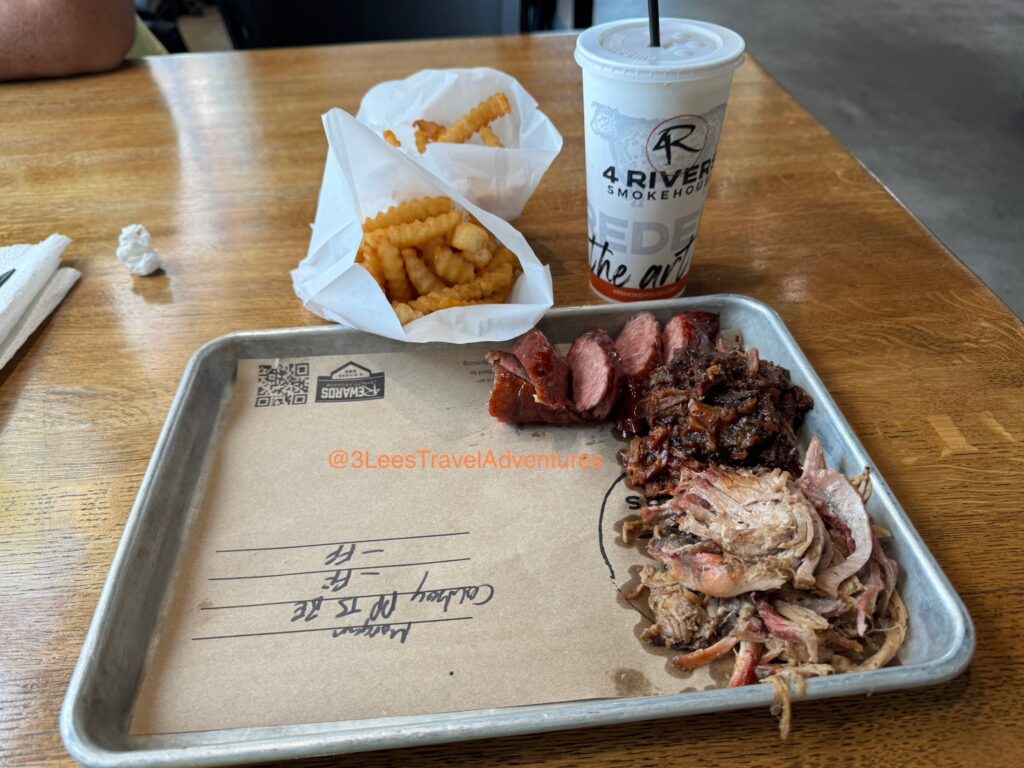 A Cowboy Combo Platter featuring Pulled Pork, Burnt Ends, Texas Sausage, and French Fries from 4 Rivers BBQ Smokehouse in Daytona Beach, FL.